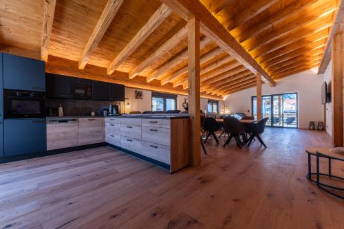 a kitchen and dining room with a wooden ceiling at Alprocks Alvaresort in Bichlbach