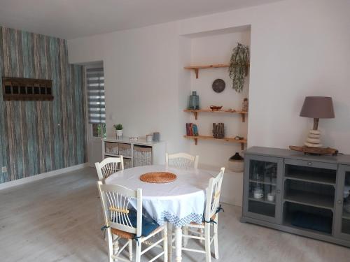 a dining room with a white table and chairs at Balade sur le port in Dinan