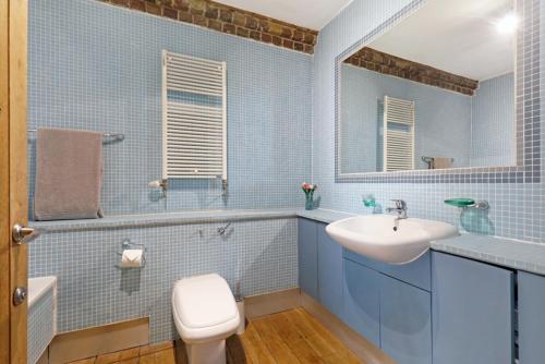 uma casa de banho azul com um lavatório e um WC em Shard View near Borough Market em Londres