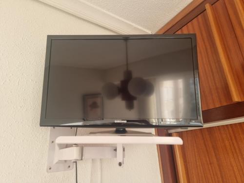a flat screen tv hanging on a wall at Habitación privada al lado de la bahía de Santander in Santander