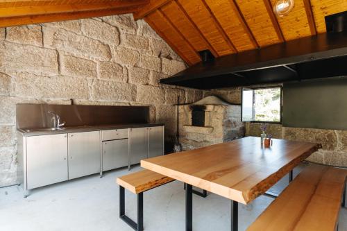 a kitchen with a wooden table and a stone wall at D'Autor Village 