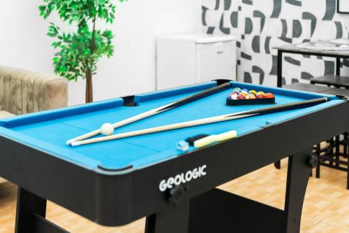 a pool table with cue balls and bats on it at Large Luxury 4 Bedroom House - Off-street Parking - Garden - Wifi - Netflix - 11M in Northfield
