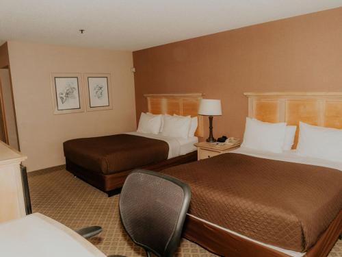 um quarto de hotel com duas camas e uma cadeira em Wallace Inn em Wallace