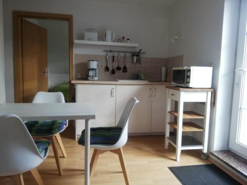 施特雷利茨的住宿－Ferienwohnung 2 Schulze，厨房配有桌椅和微波炉。