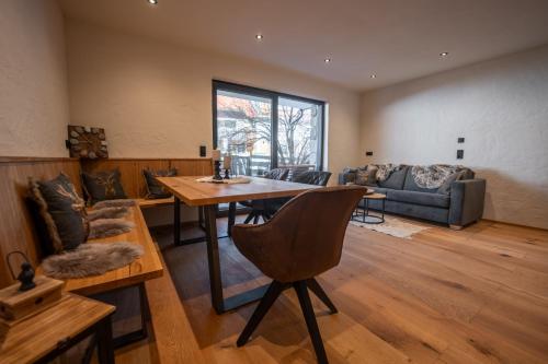 a living room with a table and a couch at Alprocks Alvaresort in Bichlbach