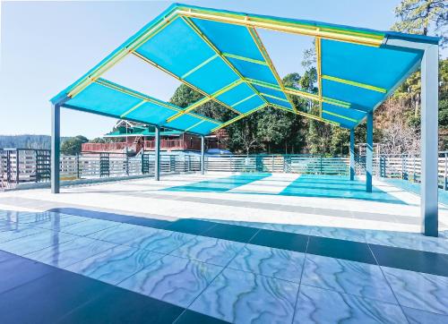 a swimming pool with a blue and yellow roof at Hotel Viva La Vida in Dalhousie