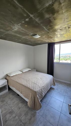 a bedroom with a bed and a large window at El Mirador in San Salvador de Jujuy