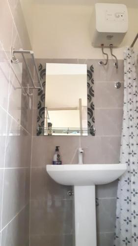 a bathroom with a white sink and a mirror at Lashibi Villas in Teshi