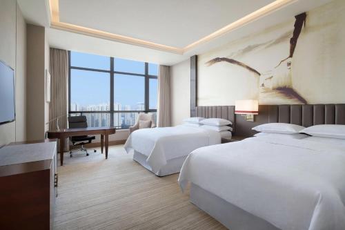 Habitación de hotel con 2 camas y escritorio en Sheraton Chuzhou Hotel, en Chuzhou