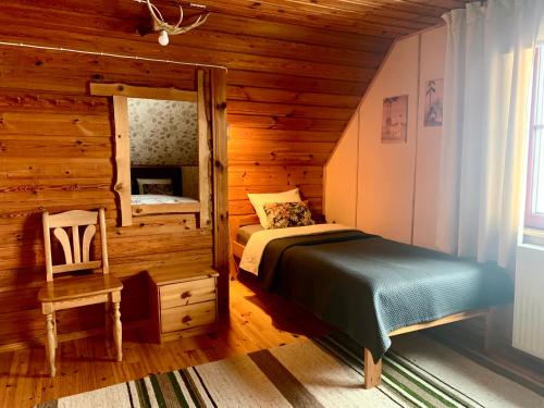 a bedroom with a bed in a log cabin at Muha Beach Holiday Home in Riksu