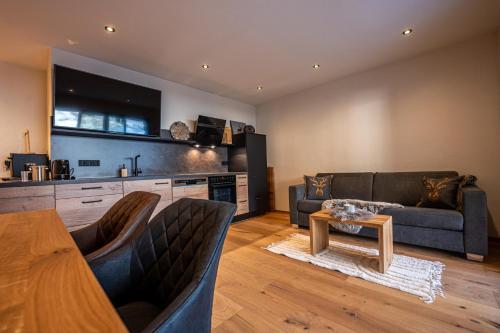 a living room with a couch and a table at Alprocks Alvaresort in Bichlbach