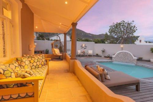 a patio with a couch and a swimming pool at Onrus Beach House in Hermanus