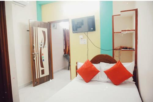 een slaapkamer met een bed met rode kussens erop bij Garuda Grand in Tirupati