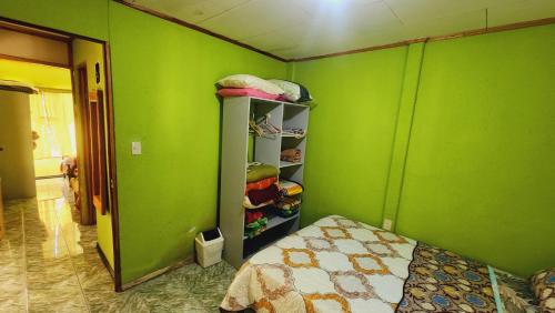 a bedroom with green walls and a bed in a room at Hospedajes Richie Eco Camp in Providencia