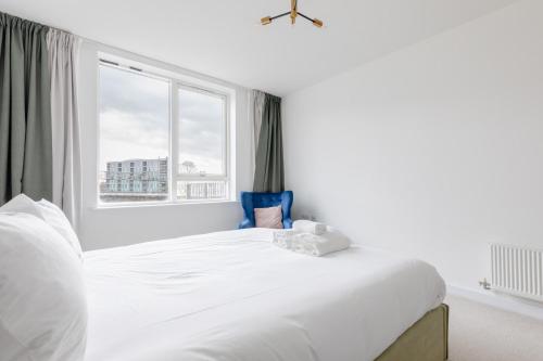a white bedroom with a large bed and a window at Chic Cosy & Well-Connected 1BD Flat Bermondsey! in London