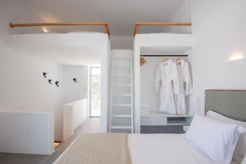 a bedroom with a white bed and a closet at Beautiful Paros Villa - 1 Bedroom - The Calming Villa - Wonderful Sea Views and Jacuzzi - Naousa in Livadia