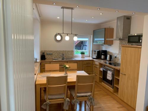 a kitchen with a wooden table and chairs in it at Ferienwohnung Janus Altstadt-Hameln Haus 2 inklusive Parkplatz - mit und ohne Terrasse oder Loggia in Hameln