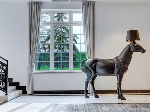 statua di un cavallo in una stanza con finestra di Hotel Arche a Częstochowa