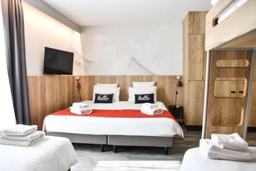 a bedroom with two beds and a tv on the wall at Hotel Mercure Château de Fontainebleau in Fontainebleau