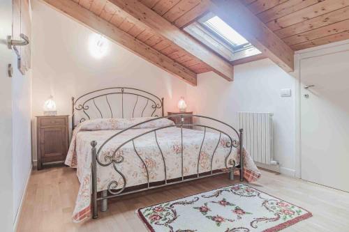 1 dormitorio con cama de metal y alfombra en Villa Claudia, en Mandello del Lario