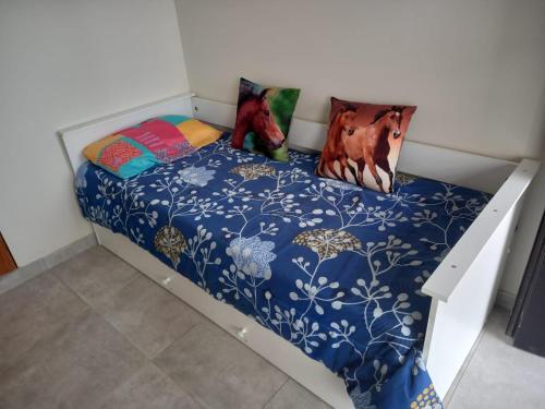 1 dormitorio con 1 cama con edredón azul en Complejo multiespacios en Trelew