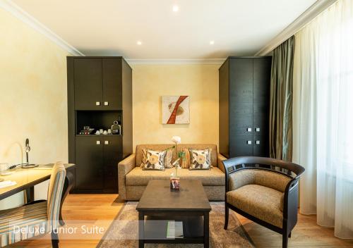 a living room with a couch and a table at Lenkerhof gourmet spa resort - Relais & Châteaux in Lenk