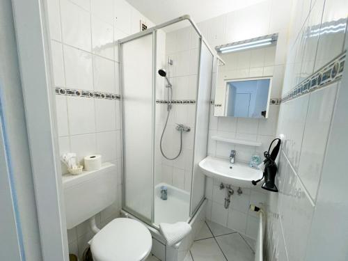 uma casa de banho com um chuveiro, um WC e um lavatório. em Apartment für 4 Gäste mit kostenlosen Parkplätzen und Lift em Hanôver