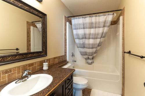a bathroom with a sink and a tub and a toilet at Cozy Countryside Crib in Grande Prairie