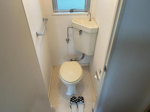 ein kleines Bad mit WC und zwei Paar Schuhe in der Unterkunft Sunglais West Park II / Vacation STAY 5855 in Fukuoka