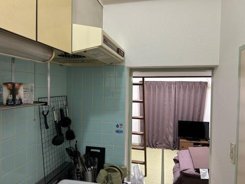 a kitchen with blue tiled walls and a window at Vintage III - Vacation STAY 14774 in Fukuoka