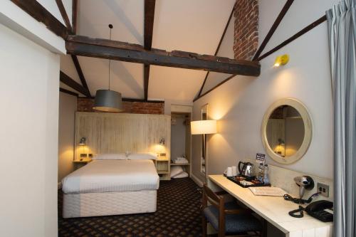 a hotel room with a bed and a desk at The King's Head Hotel Wetherspoon in Beccles
