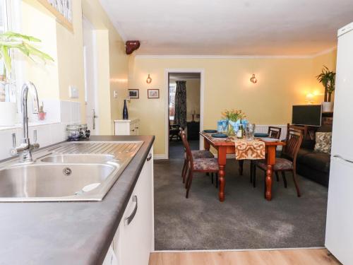 cocina y sala de estar con mesa, cocina y comedor en Millers Cottage, en Malton