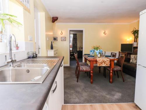 a kitchen and living room with a table and a kitchen and a dining room at Millers Cottage in Malton