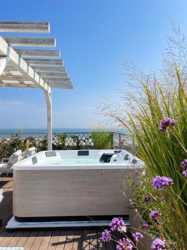 a bath tub sitting on a deck next to the beach at Hotel Villa Rosa Riviera in Rimini