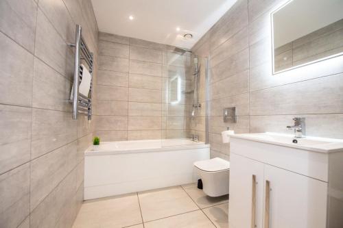 uma casa de banho com uma banheira, um WC e um lavatório. em One Bedroom Apartments in Liverpool City Centre em Liverpool