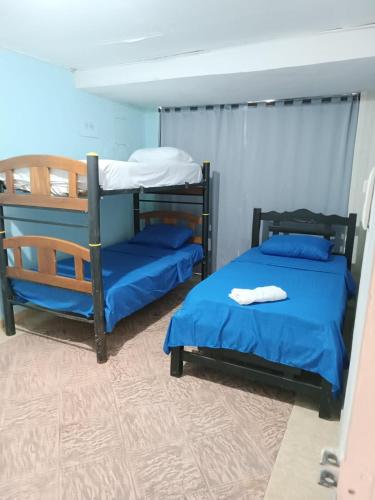 2 stapelbedden in een kamer met blauwe lakens bij Beach Airport House in Cartagena