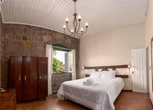 a bedroom with a large bed and a stone wall at Casa de Pedra Mena Kaho in Bento Gonçalves
