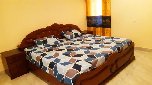 1 dormitorio con 1 cama de color azul y blanco en Lashibi Villas, en Teshi