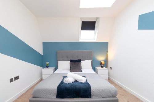 1BR Hideaway in Coventry - MH Apartment في كوفينتري: غرفة نوم بسرير كبير وبجدران زرقاء وبيضاء