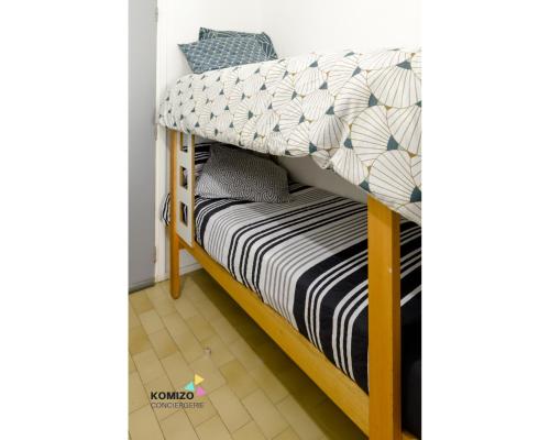 - un lit superposé avec des draps noirs et blancs dans l'établissement Le chant des vagues, à Leucate