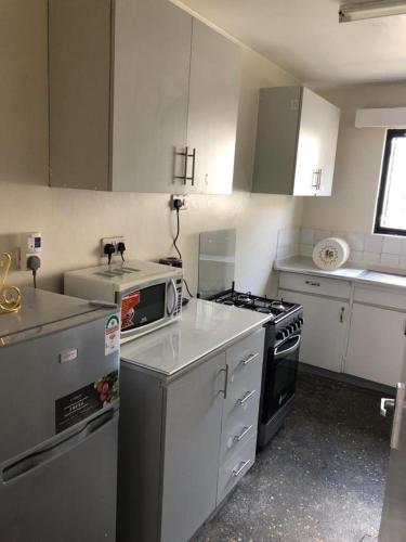 a kitchen with white cabinets and a stove top oven at Homes by Val in Nairobi