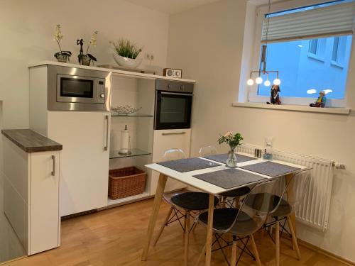 a small kitchen with a table and a refrigerator at Ferienwohnung Janus Altstadt-Hameln Haus 2 inklusive Parkplatz - mit und ohne Terrasse oder Loggia in Hameln