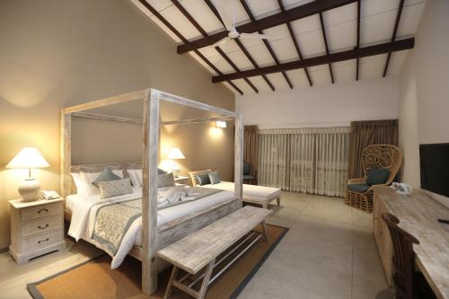 sypialnia z łóżkiem z baldachimem i ławką w obiekcie The Beach Boutique w mieście Uswetakeiyawa