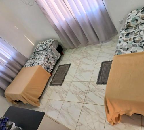 a room with two beds and a tiled floor at INGA in Ituzaingó