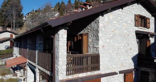 a building with a balcony with a dog on it at Casa Emy in Adrara San Rocco