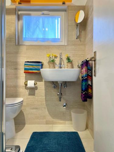 a bathroom with a sink and a window and a toilet at Bnbook Lago Maggiore Studio in Castelletto sopra Ticino