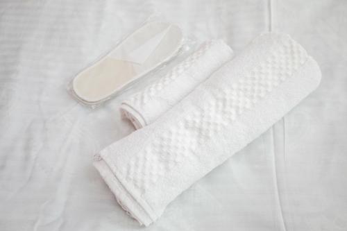 een paar witte handdoeken bovenop een bed bij city point in Koetaisi