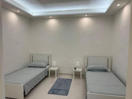 two beds in a room with two tables at La Casa Di Nonno Roberto in Livorno