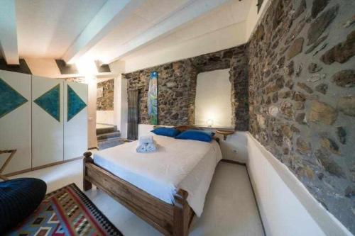 ein Schlafzimmer mit einem Bett in einer Steinmauer in der Unterkunft Chiarissima dei Venti in Aulla