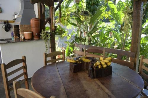 a wooden table with a bunch of bananas on it at Suítes Paquetá Ilhabela in Ilhabela